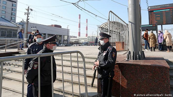 Three police officers patrol a train station in Moscow